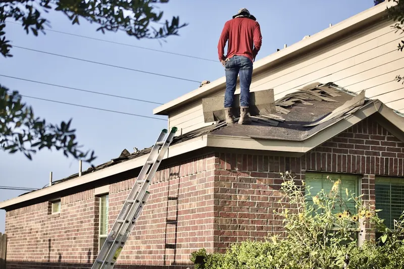 Professional roofer working on a residential roof in Arcade Village